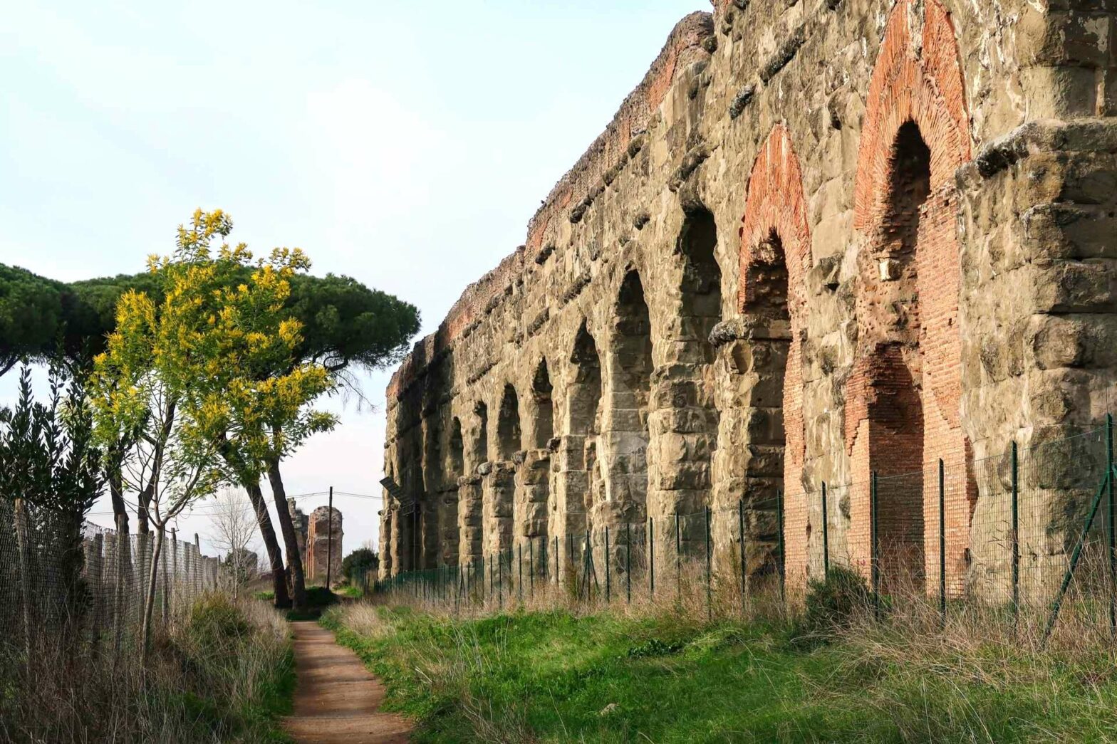A path by an aqueduct in the Park of the Aqueducts in Rome